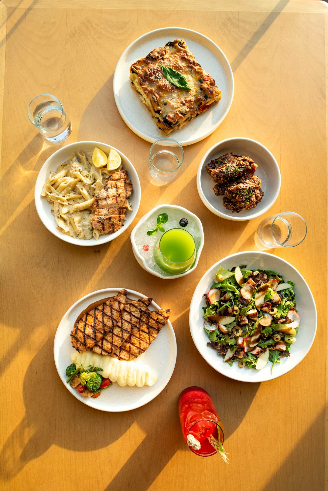 Various delicious dishes are arranged on a wooden table.